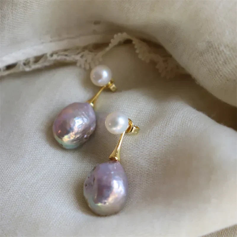 Elegant gold-coloured earrings with lilac pearl